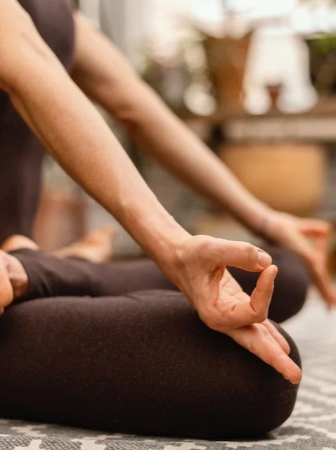 Dame met bruineyogabroek zit in meditatiehouding