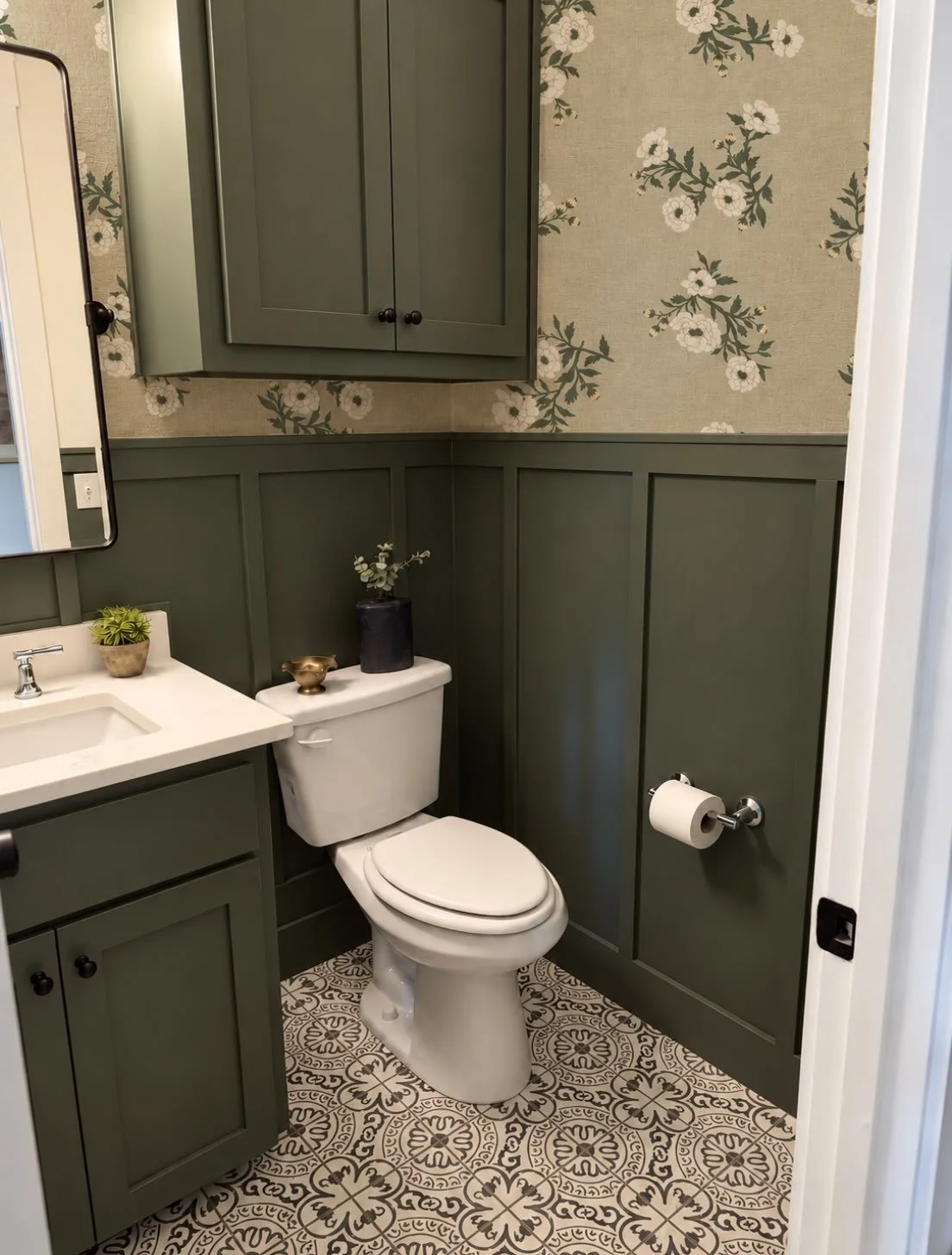 A little floral charm, a little moody green. 🌿

Soft ivory blooms and delicate botanical details bring a collected, timeless feel to this powder room. Paired with Sherwin-Williams Pewter Green wainscoting, the wallpaper adds just the right touch of 
