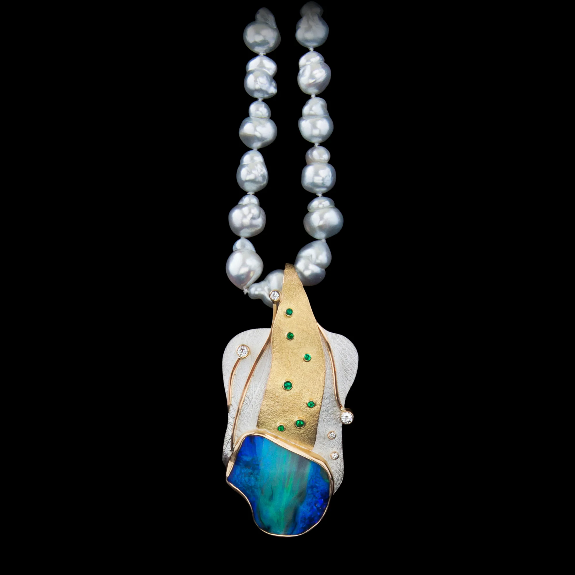FRIDA | Fine Jewellery. Shield™ Collection, Ingemar pendant on pearls. One-of-a-kind pendant in sterling silver and 18kt yellow gold set with a rare black opal, emeralds and brilliant-cut diamonds.