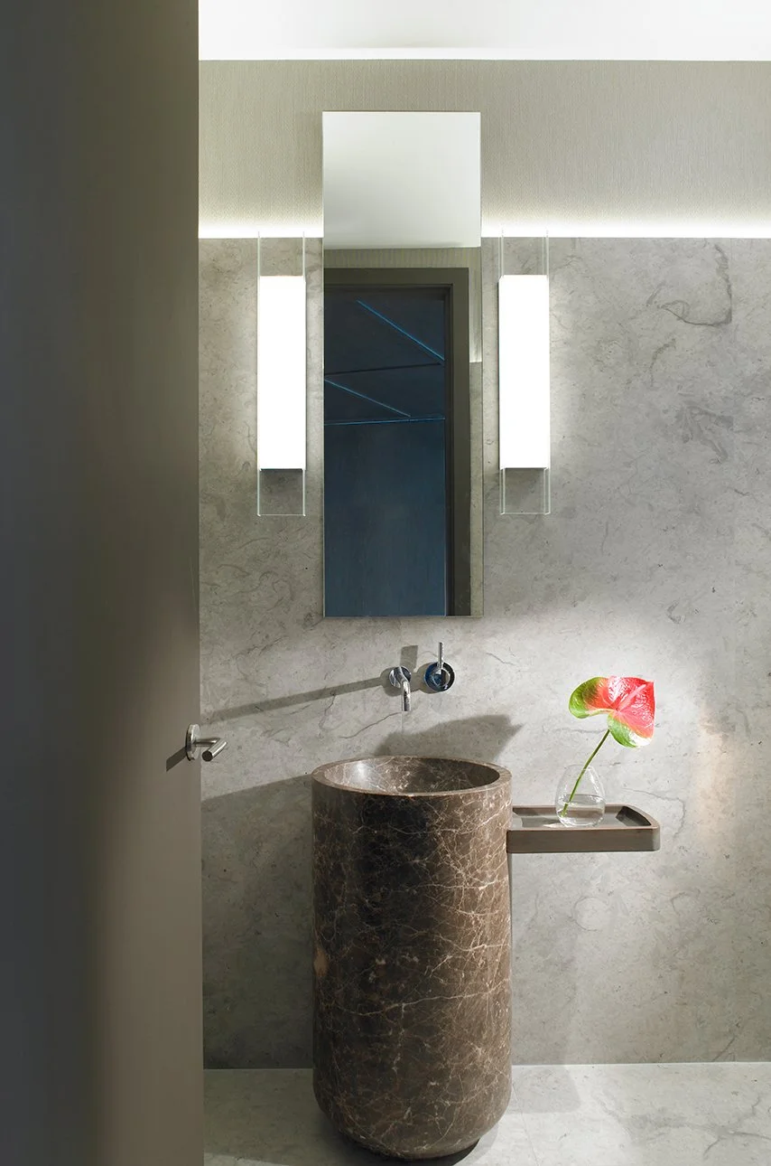 Sleek modern powder room featuring a freestanding brown marble cylindrical basin sink.