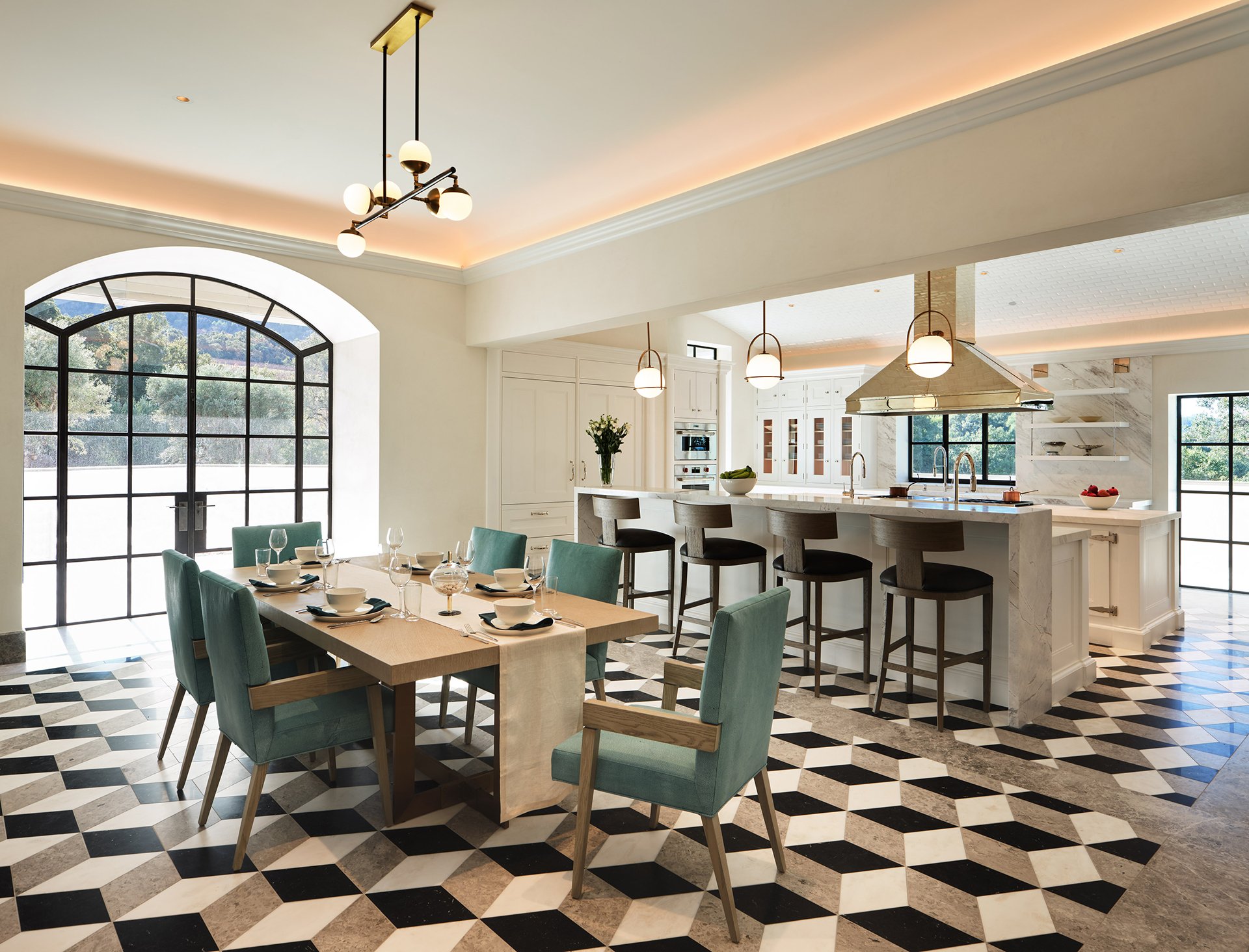 White kitchen with dining area: mosaic 3d floors, long marble island with bar seating, and modern lighting.
