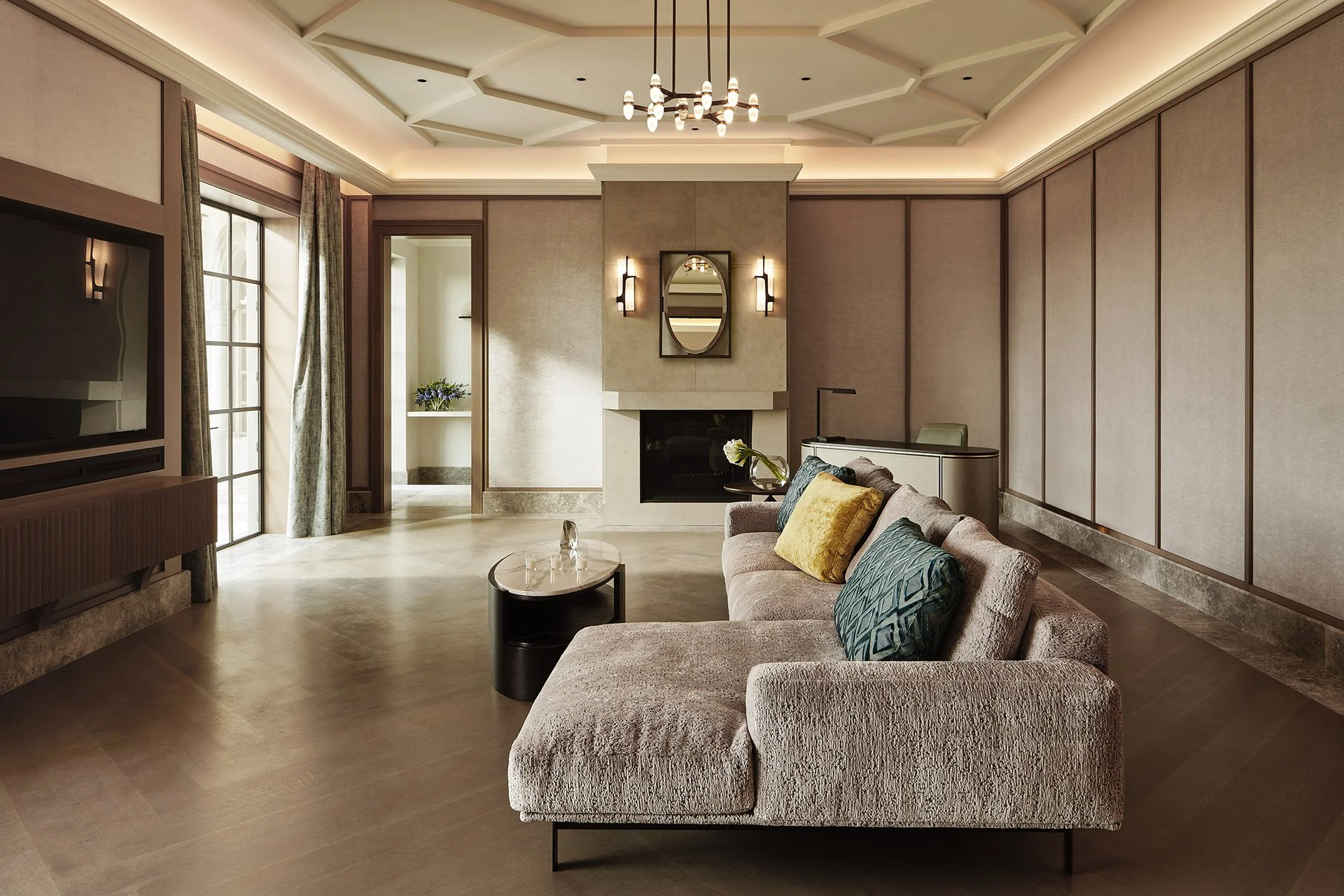 Modern bedroom lounge by Michael Wolk Design with a textured sectional, stone fireplace, and paneled walls/