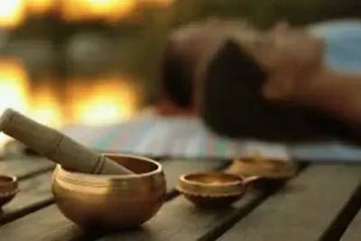 Holistic retreat therapies_Numerous singing bowls in the foreground with clients meditating in the background