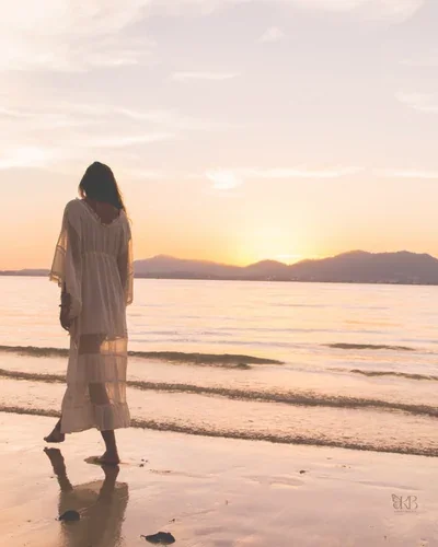 Woman walking calmly on the beach in reflection