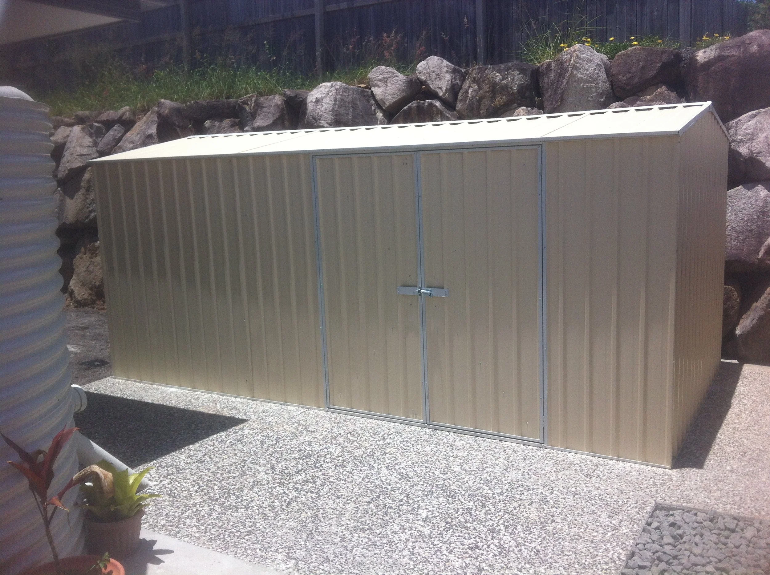 Garden Shed surrounded by an exposed concrete footpath in Brisbane