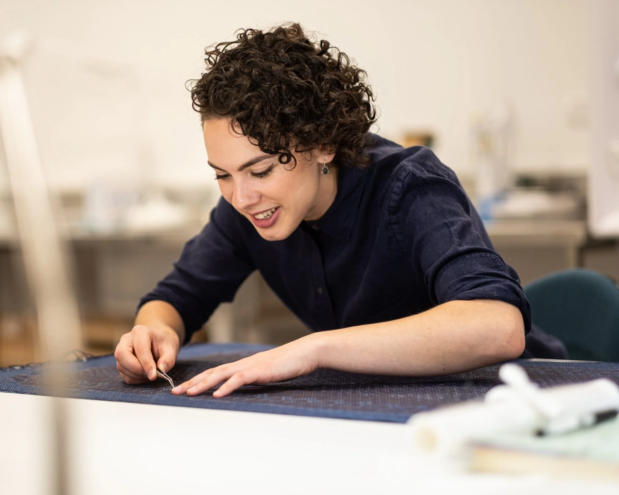 Kate Blair, textile conservator working on Maori pokinikini (harakeke, New Zealand flax, Phormium Tenax)