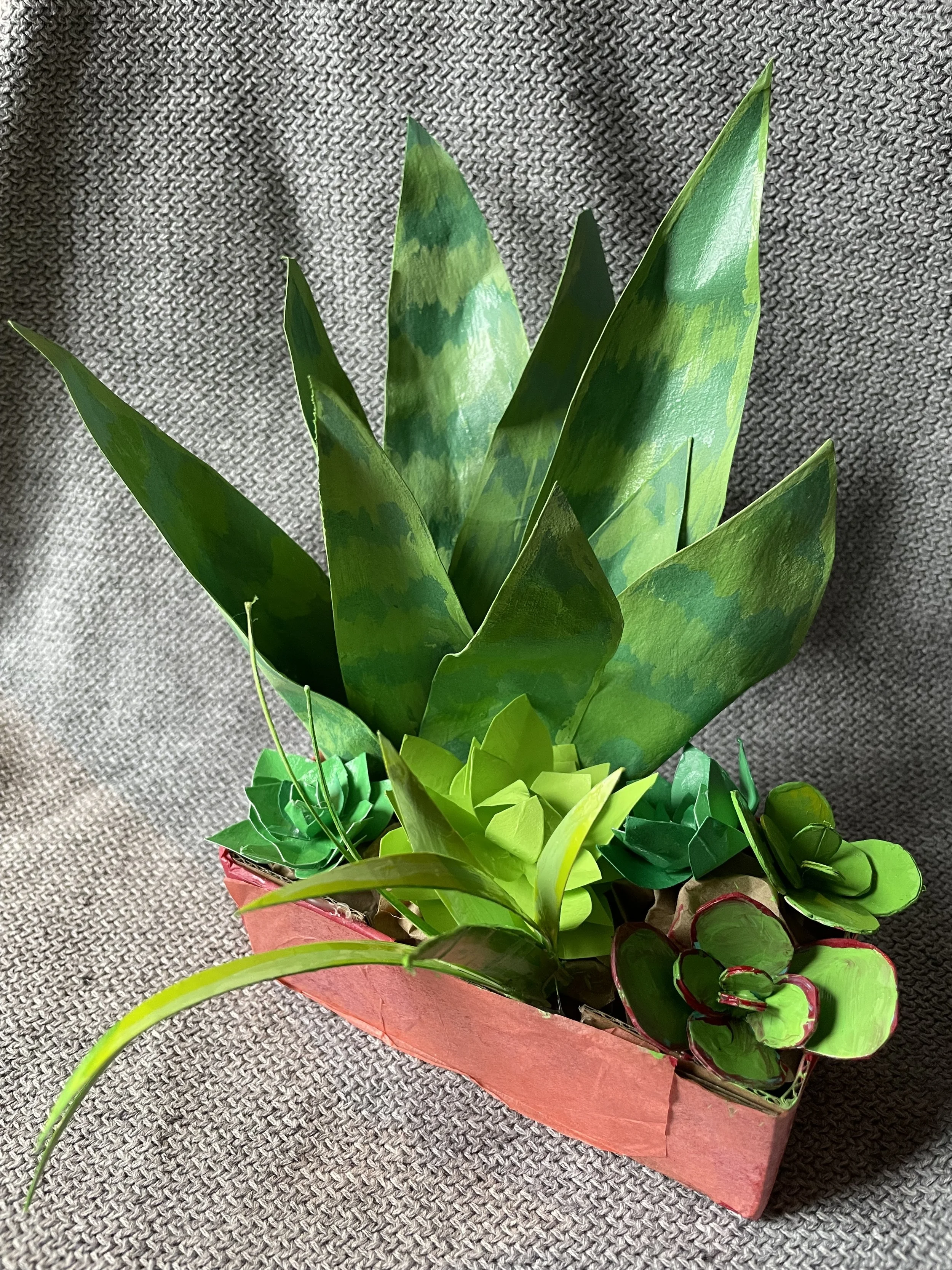  Cardboard, masking tape, paper mache, cardstock, acrylic paint, glue. 