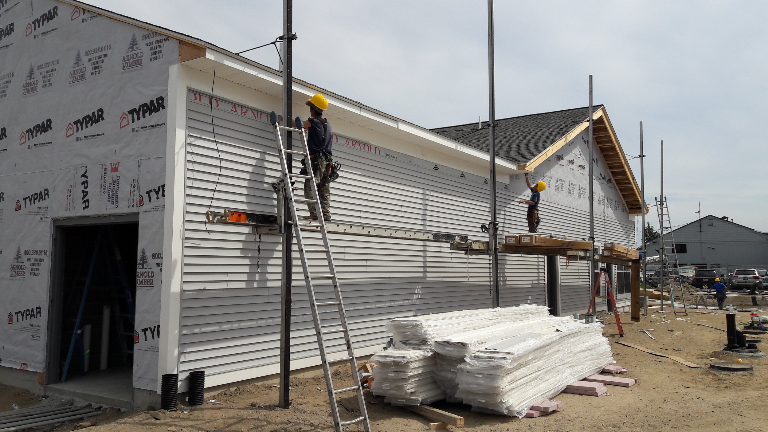  The siding crew begins installing vinyl siding on the facade. 