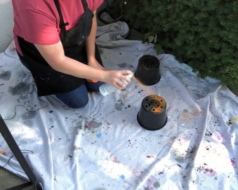How to paint ugly plastic flower containers. Spray painting mum bases for fall. Decorating your fall porch on a budget