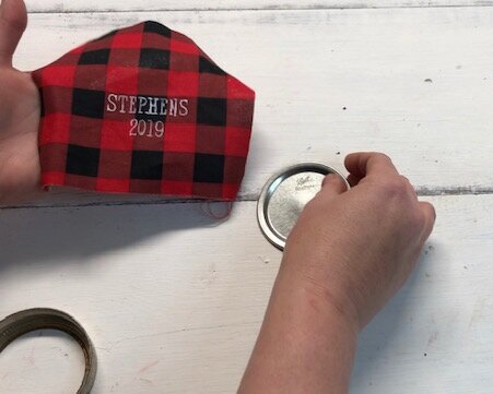 DIY personalized mason jar lid ornament using buffalo plaid. How to make Christmas ornaments out of rusty canning jar lids and your Cricut