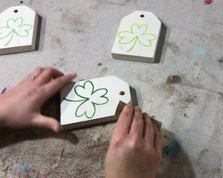 DIY craft kit for adults. How to make mini wood tags for St. Patrick's Day using your Cricut. How to stenicil wood signs for spring. How to distress handpainted wood signs using sandpaper.