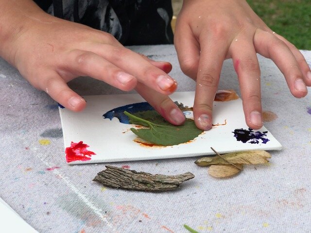 How to paint with nature, a fun outdoor craft to do with your kids. Paint on a dollar tree canvas with nature using food coloring, flowers, twigs, leaves.