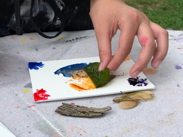 How to paint with nature, a fun outdoor craft to do with your kids. Paint on a dollar tree canvas with nature using food coloring, flowers, twigs, leaves.