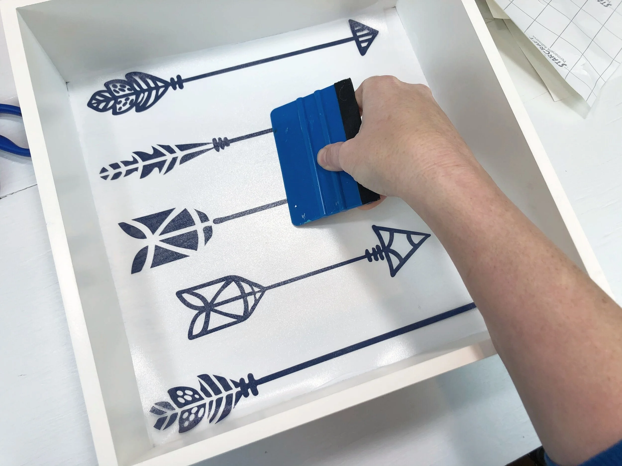 DIY boho shelf decals using your Cricut. How to makeover outdated floating cub shelves for a boho inspired bedroom. Feather, arrow, and geometric shapes for bohemian style home decor.