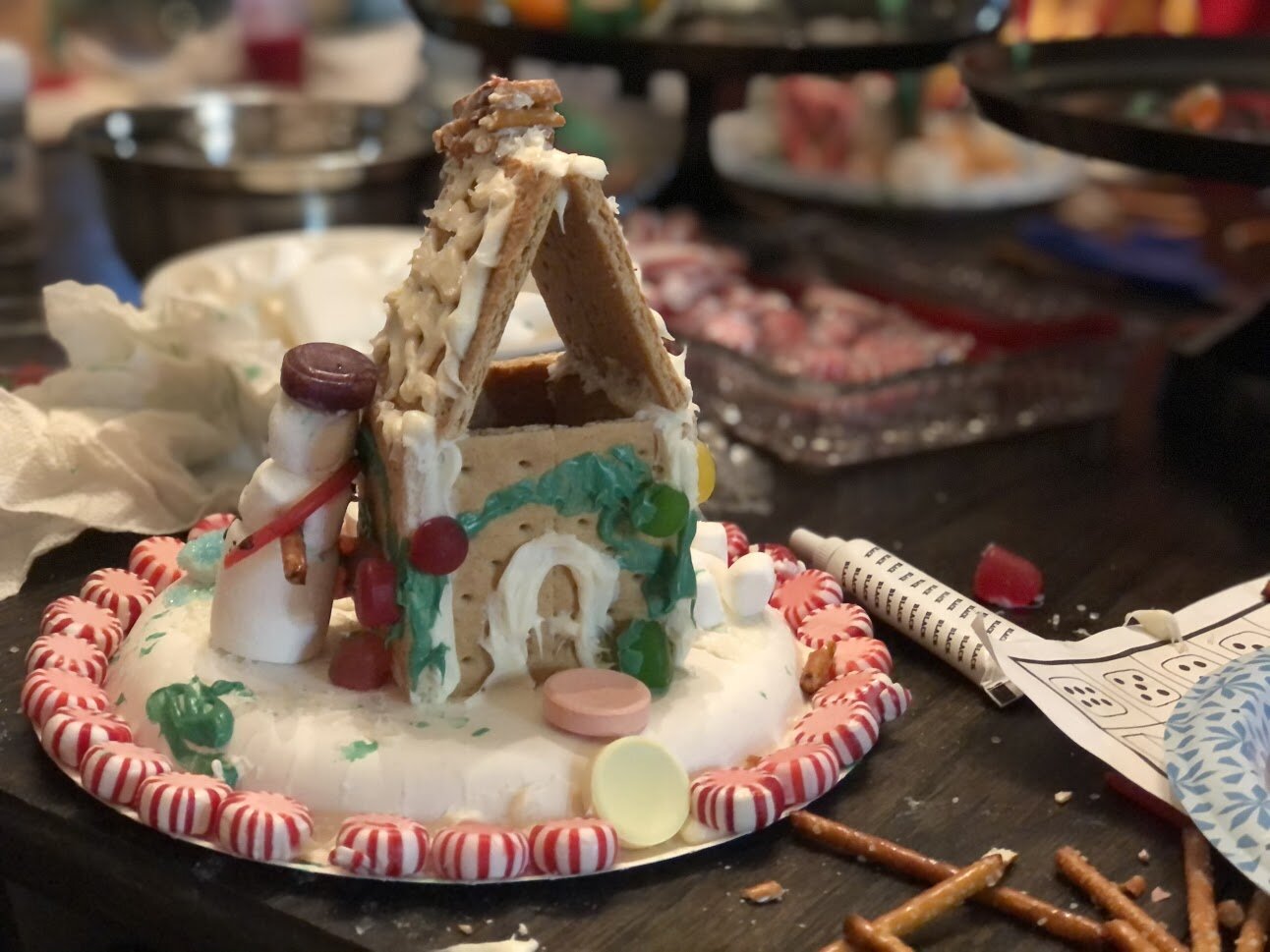 Kid friendly gingerbread house decorating party using graham crackers. How to have a stress free Christmas tradition party with your kids. Decorating gingerbread houses as a family. How to make easy gingerbread houses for kids.