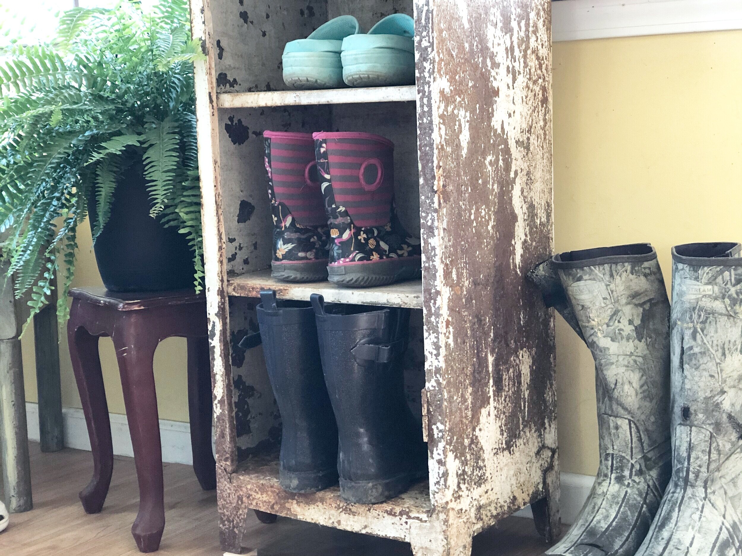 Rusty locker / metal cabinet repurposed for a mudroom sunporch. Turn an antique chipped paint locker into a shoe holder for your mudroom. Frugal rustic farmhouse furniture for your storage needs.