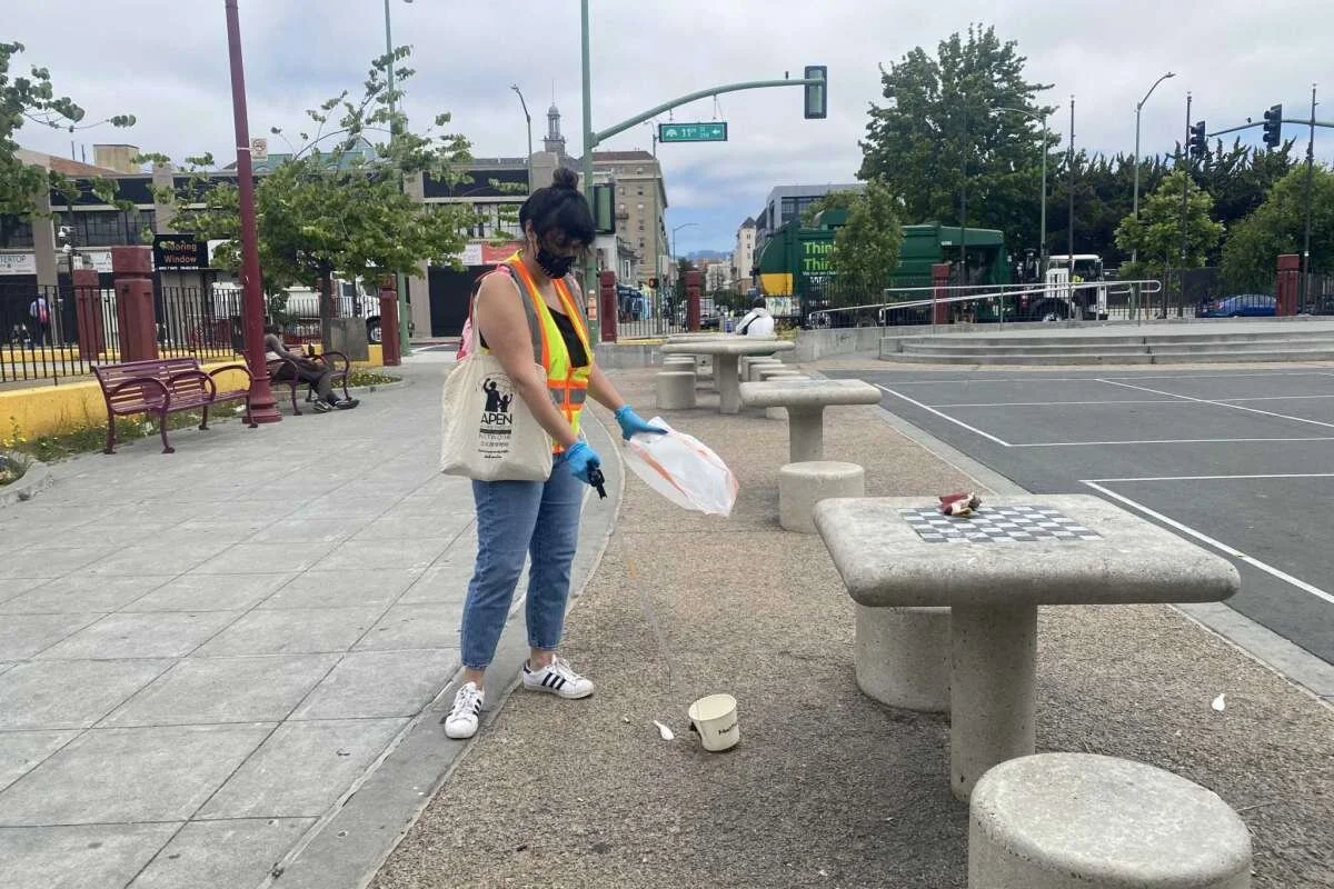 Volunteer Amanda Farrell collects trash at Lincoln Square Park in Oakland.Courtesy Vanessa Hua