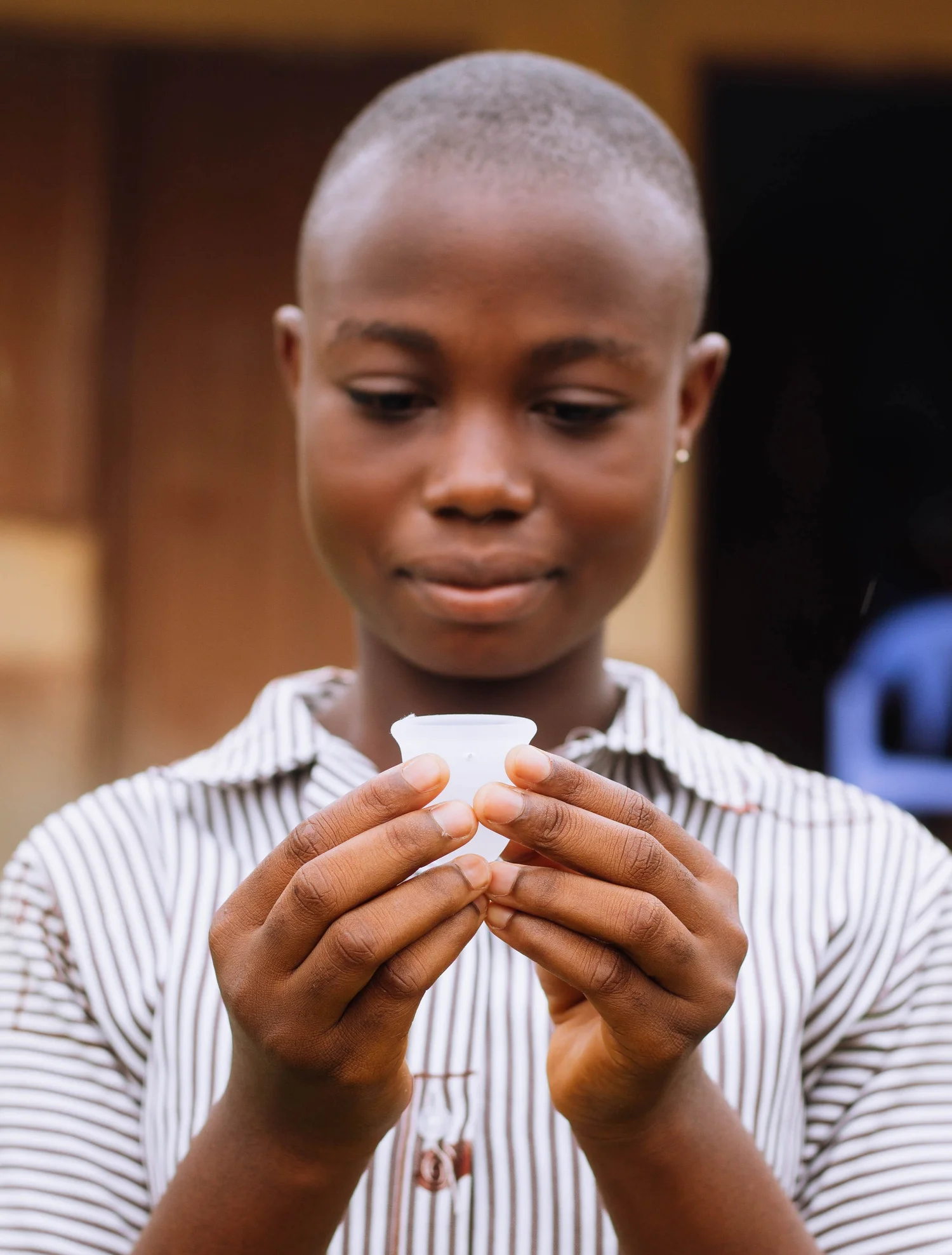 A young woman holding a reusable menstrual cup