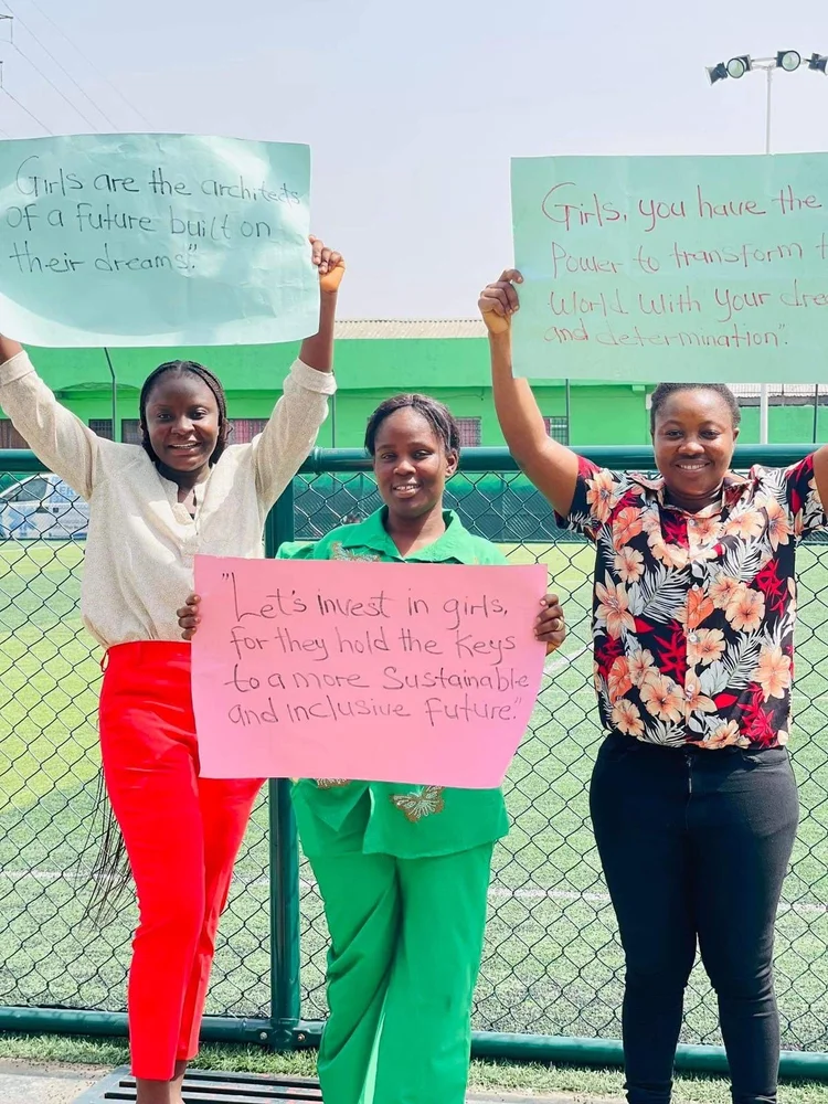 Educate West Point team holding signs supporting girls in Liberia