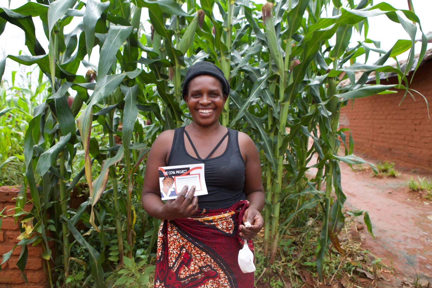 A Cova community member holding menstrual health education materials