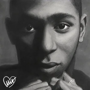 Black and white close-up portrait of a young person with short hair, looking directly at the camera.