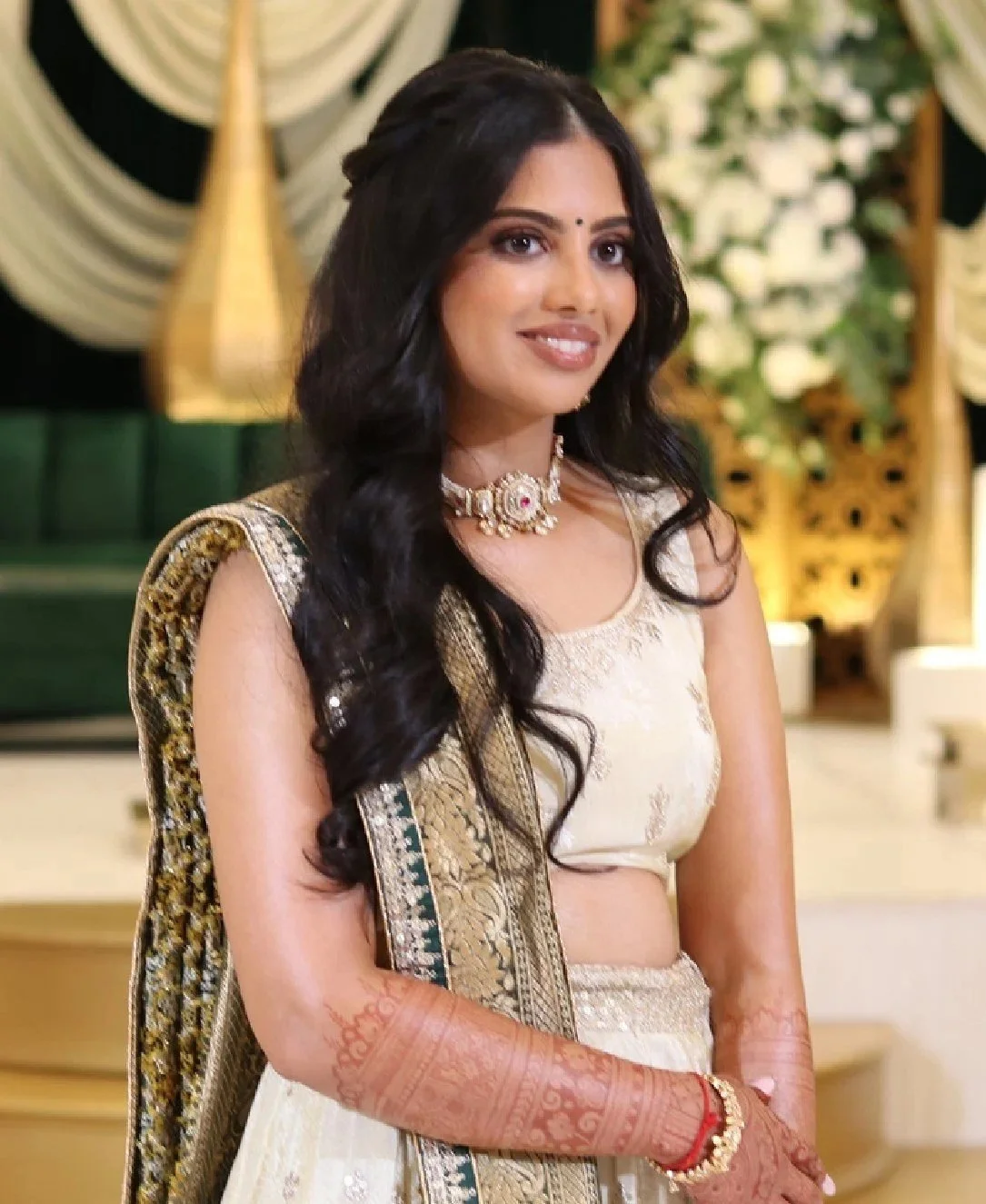 Bride in ivory lehenga with soft waves by Red Lotus Artistry