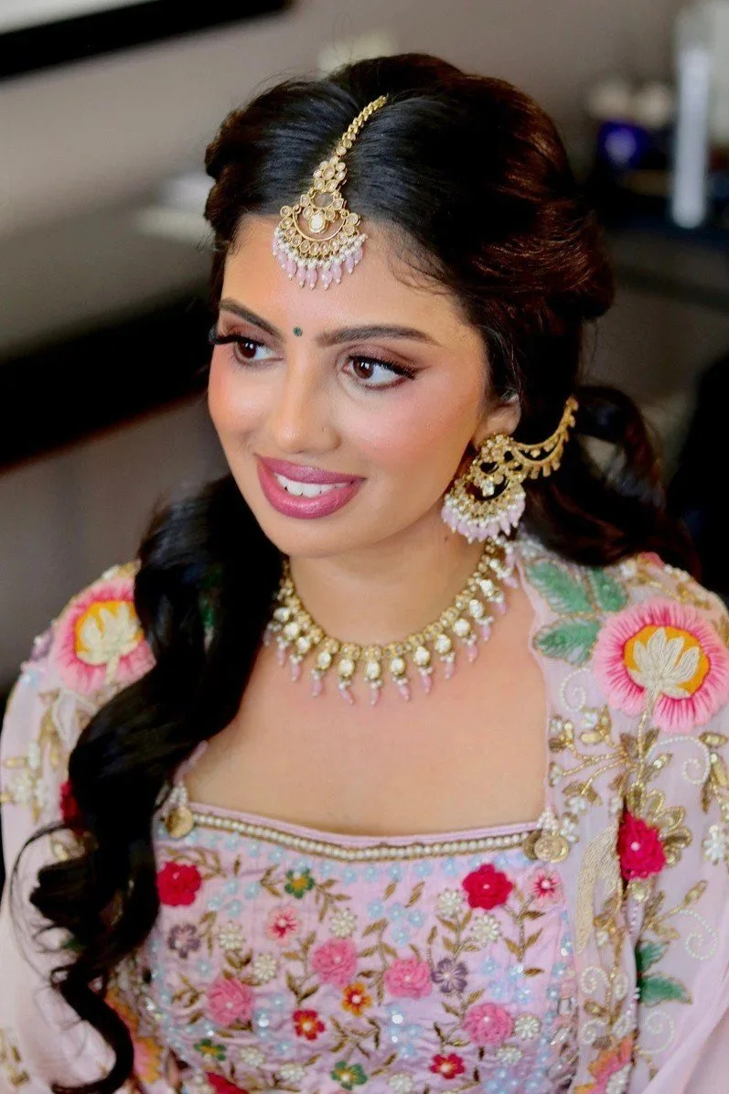 Bride in floral lehenga with soft curls by Red Lotus Artistry, The Luxe Experience