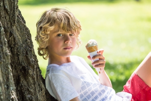 a-young-boy-sitting-against-a-tree-holding-an-ice-cream-austockphoto-000027199.jpg
