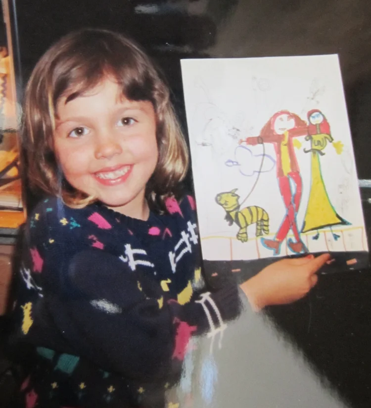 Whitney L Anderson as a little girl holding up one of her first drawings