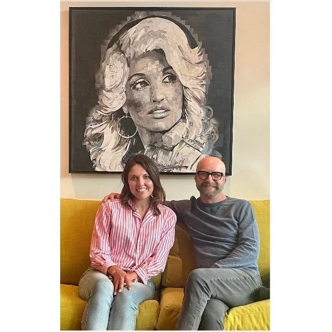 Collectors smiling beside their commissioned portrait
