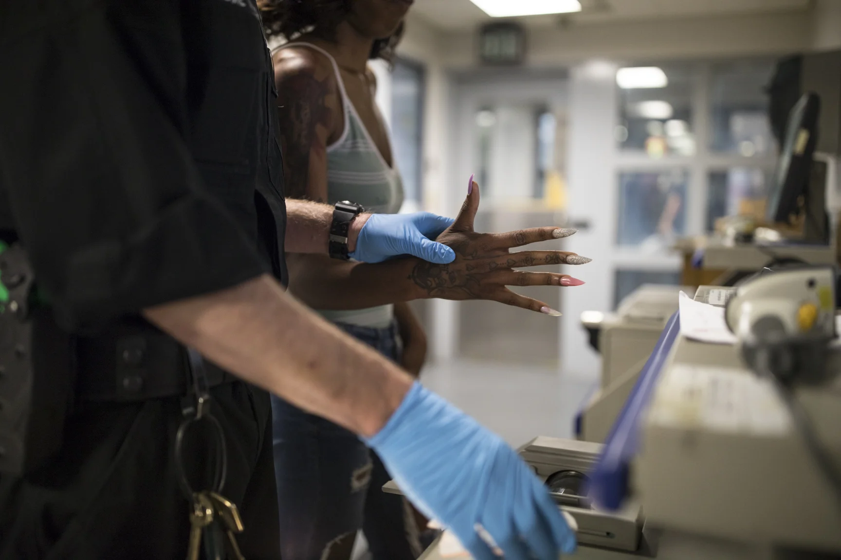 May 17, 2017: An officer of the Los Angeles Police Department fingerprints a 17-year old woman following her arrest in the southeast area of Los Angeles, California for soliciting an undercover police officer for the purpose of prostitution.