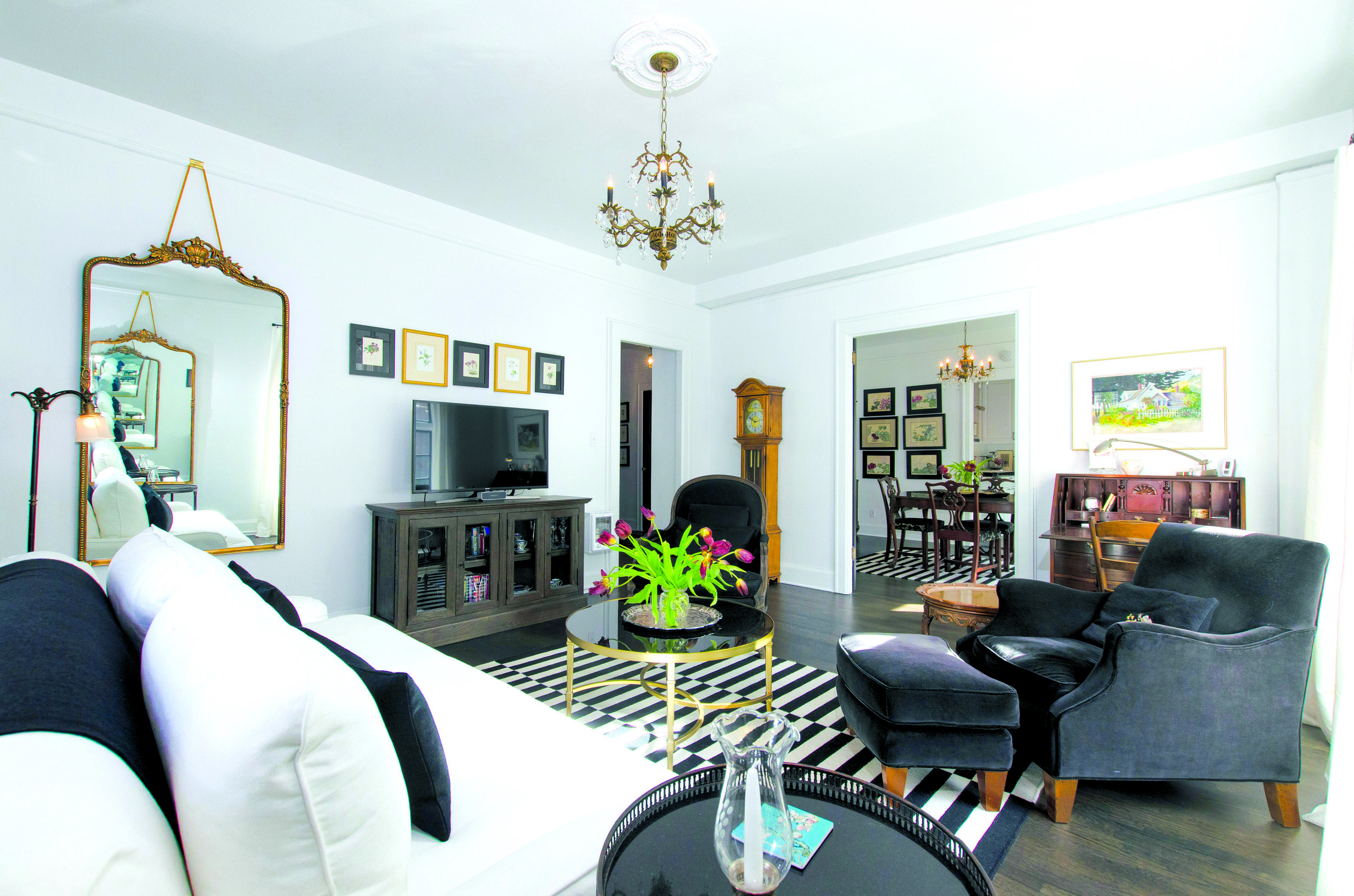 Lovingly updated, with sultry antique French light fixtures, dark hardwood floors, and fresh paint throughout.