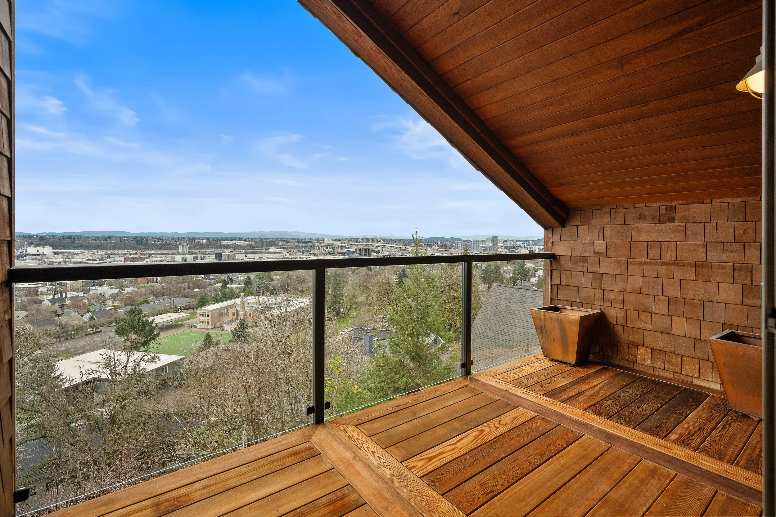  The lower level offers exceptional flexibility with a second en suite primary bedroom with private deck access, two additional bedrooms, full bath, laundry, and a spacious rec room with soaring ceilings. 