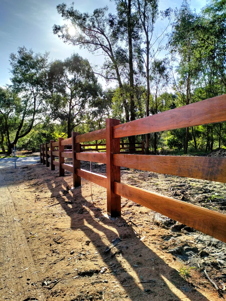 Three-rail Ironbark fencing beside a rural driveway