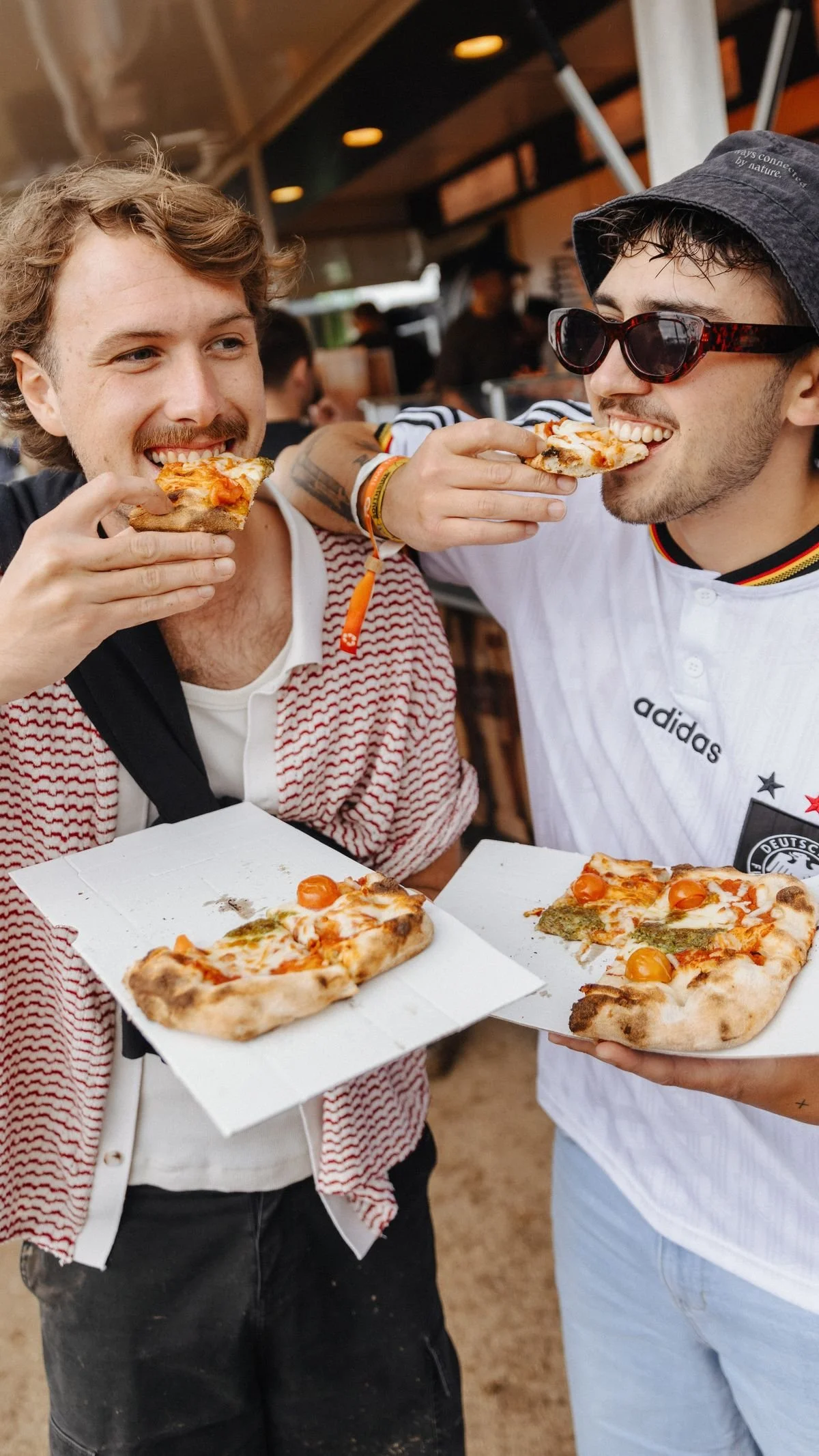 Two friends enjoying pizza from a food stall at CronullaFest, Cronulla