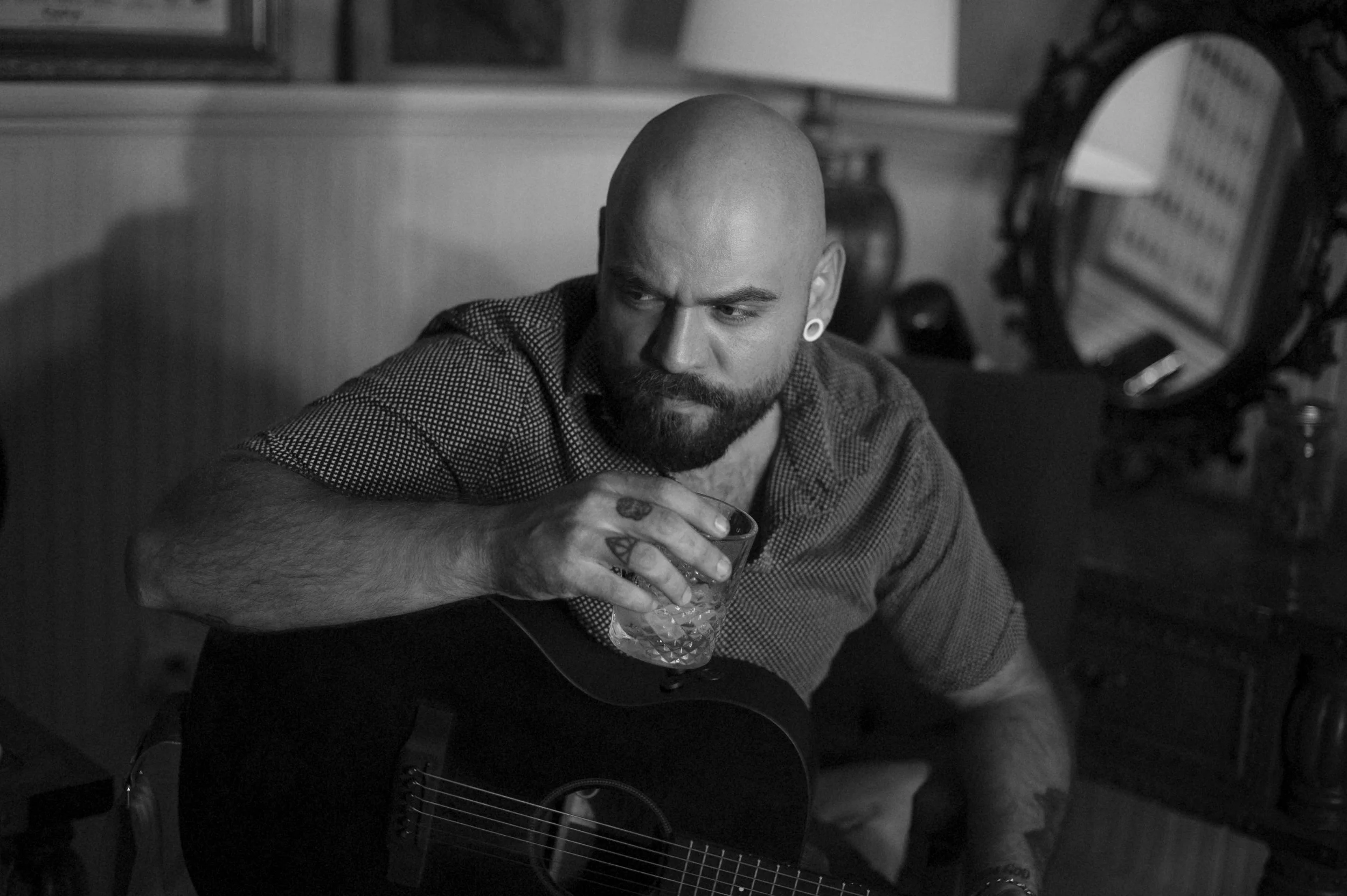 Black-and-white portrait of Vinnie Hines seated with an acoustic guitar.