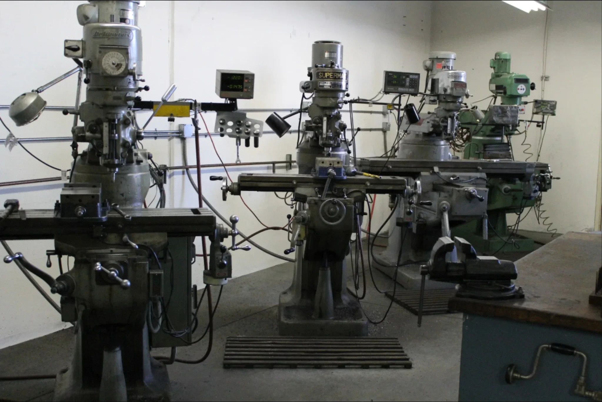 Manual milling machines set up for precision machining and custom metal work