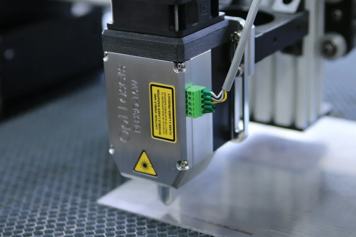 Fiber laser engraving head marking a metal surface with precision detail