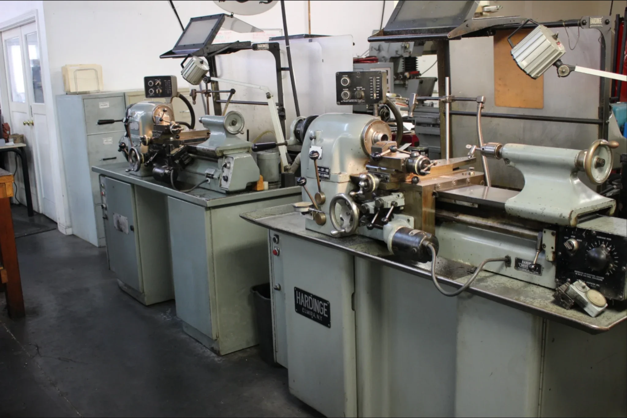 Manual turning lathes configured for precision machining of cylindrical metal parts