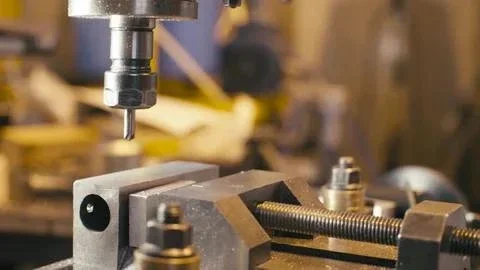 Close-up of a manual milling operation cutting a metal component during custom part fabrication