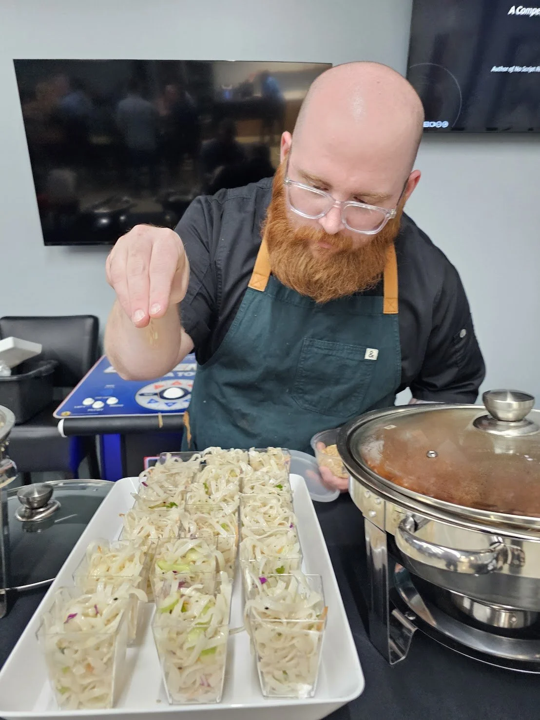 Personal professional chef adds seasoning to a gourmet catering at a corporate networking event.