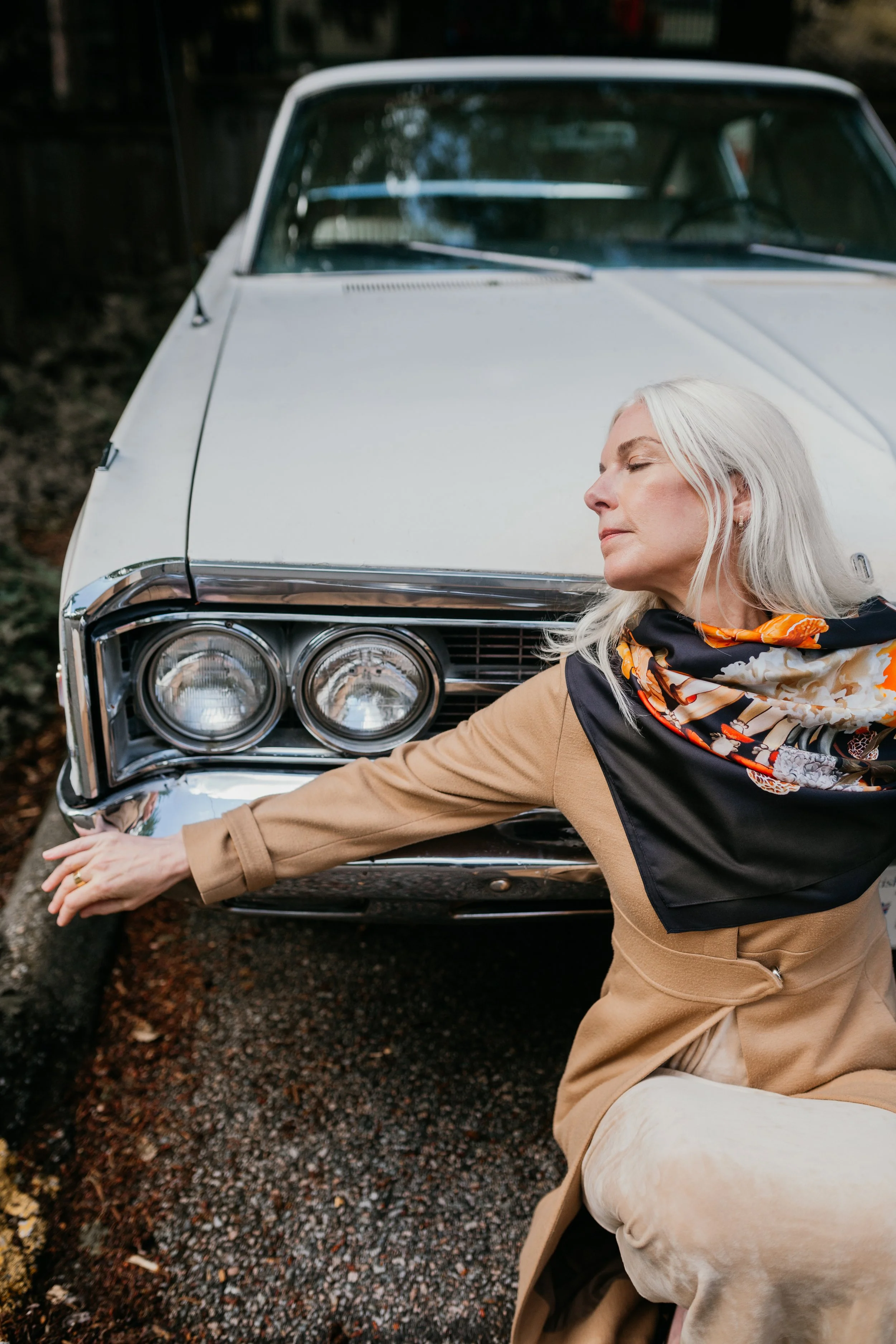 UNITY - in Black - silk scarf — styled with a tan coat, leaning on a vintage car
