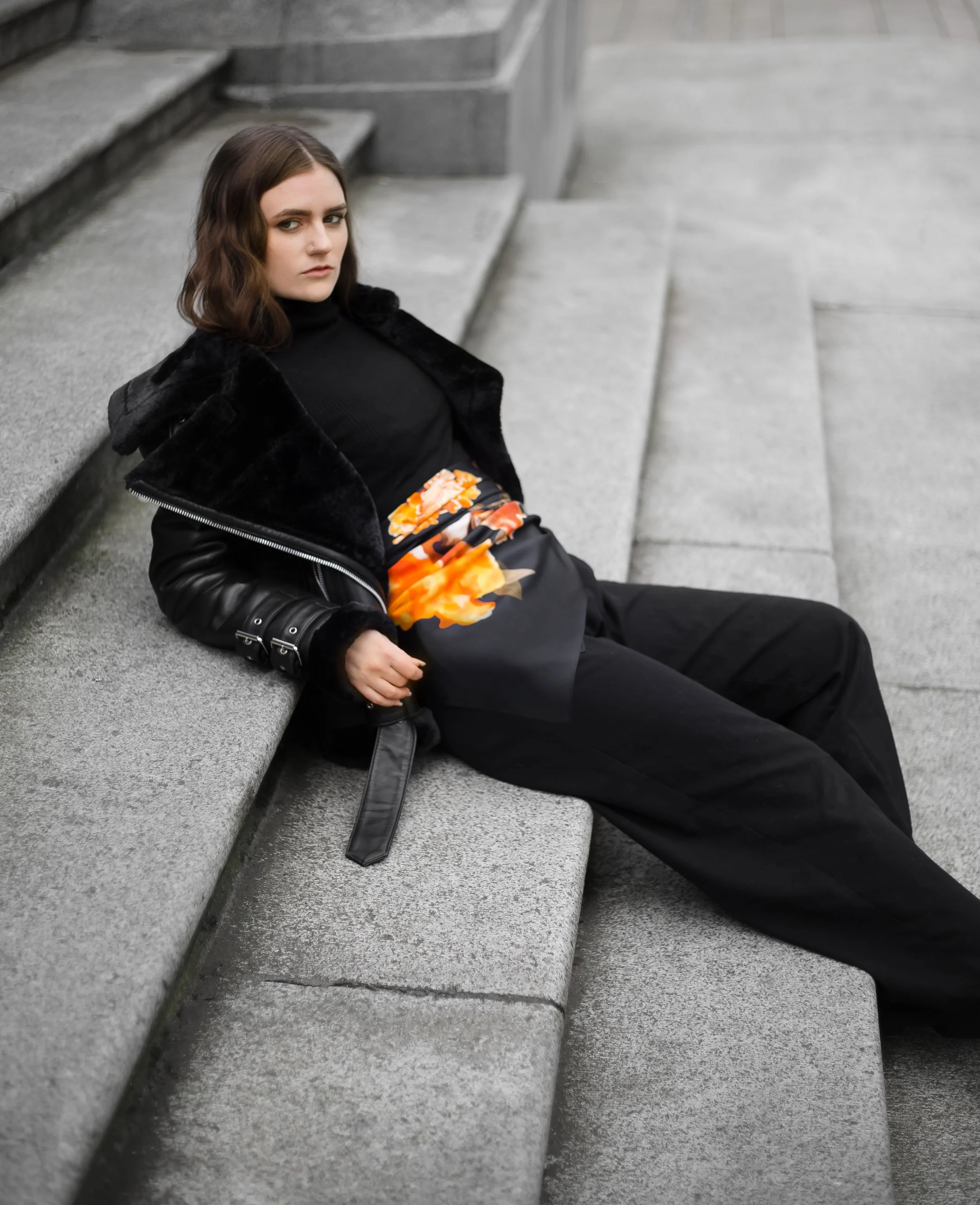 UNITY - in Black - silk scarf — draped over the lap, seated on stone steps