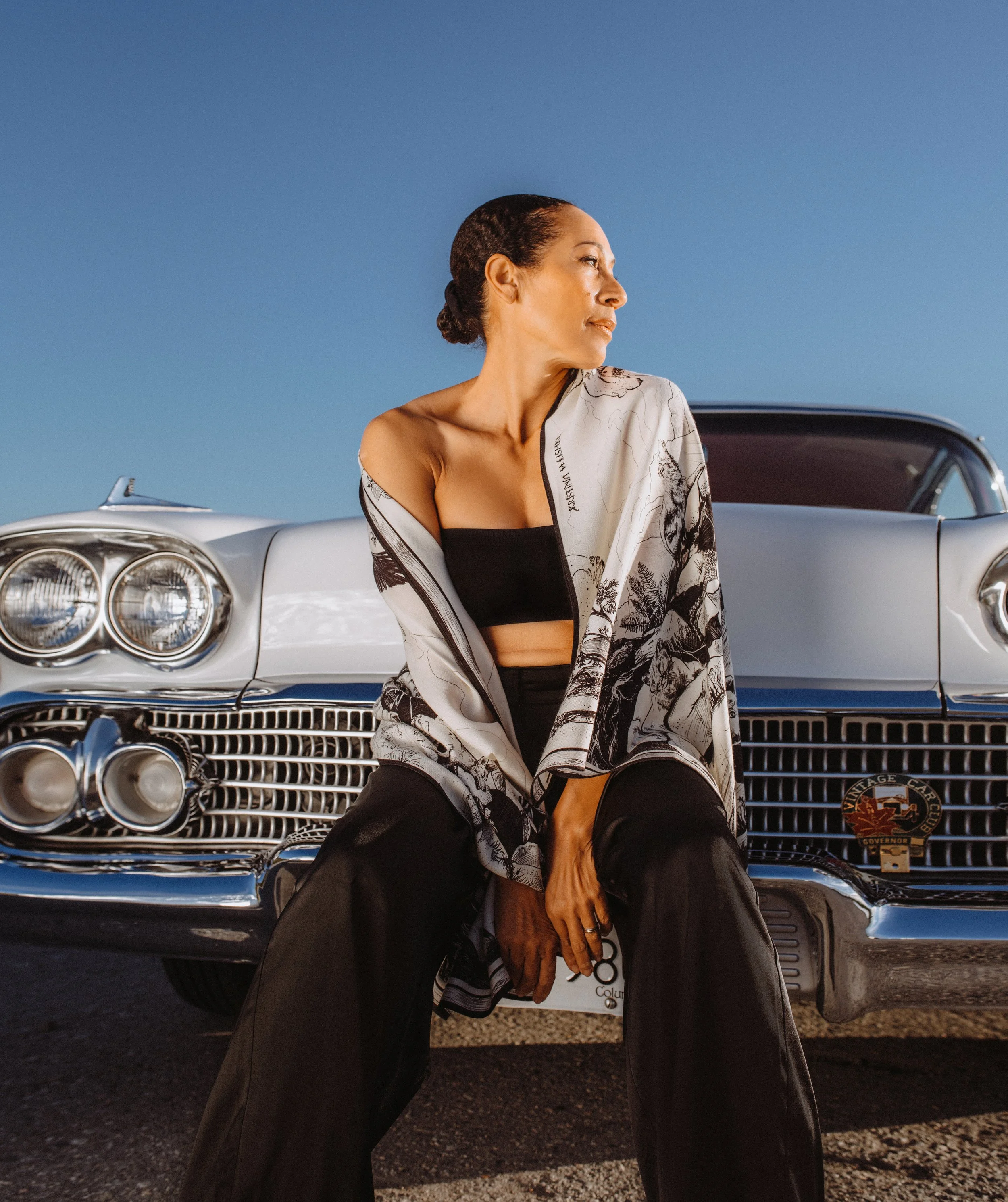 DEEP FOREST in black and white wool silk shawl — worn sitting on a vintage car