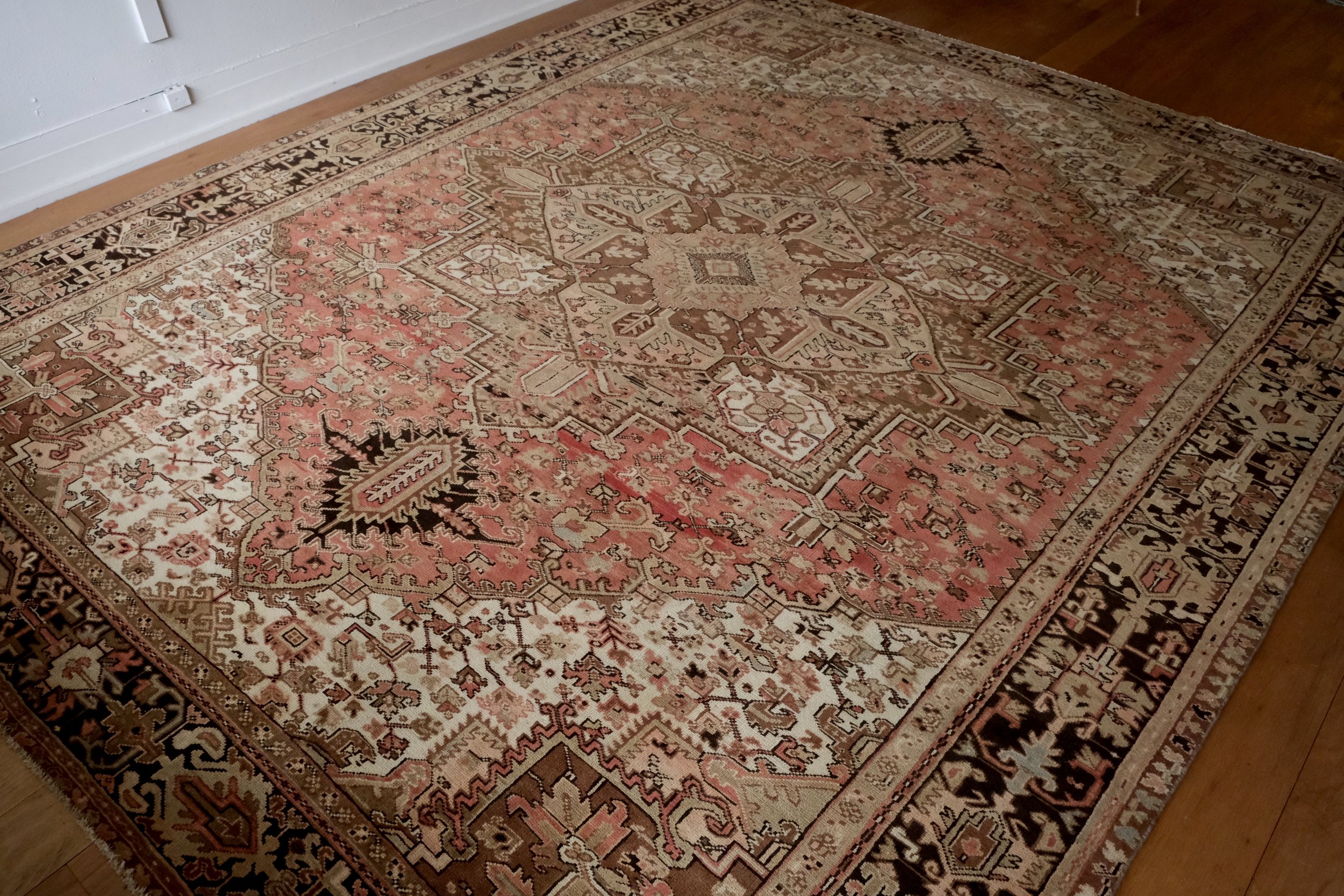 a diagonal look at the vintage Persian Heriz rug displayed in the studio