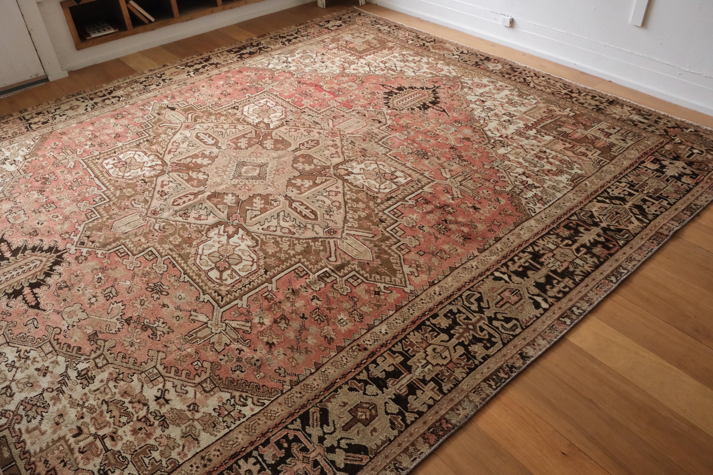 a diagonal look at the vintage Persian Heriz rug displayed in the studio