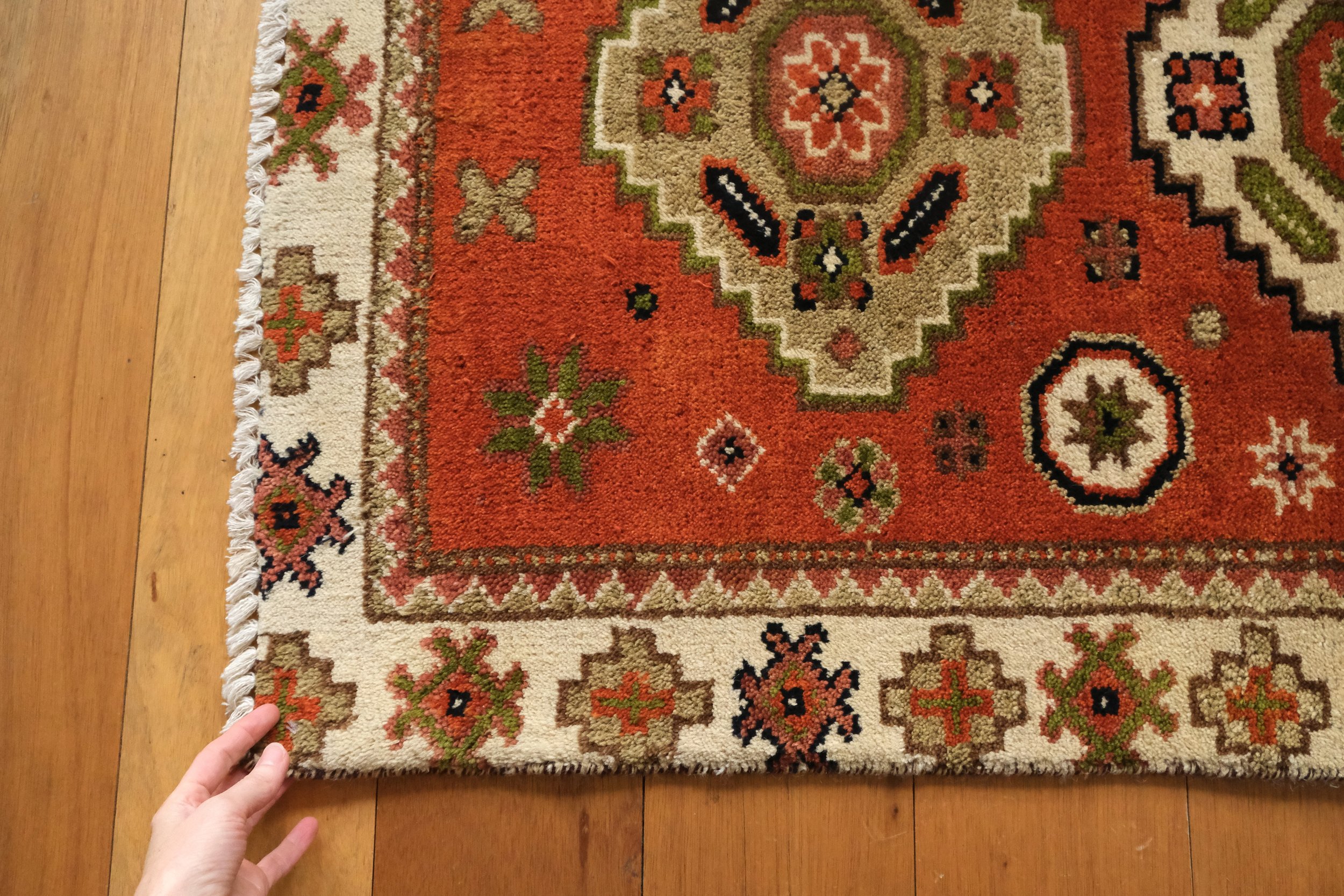 the corner of the turkish rug being held