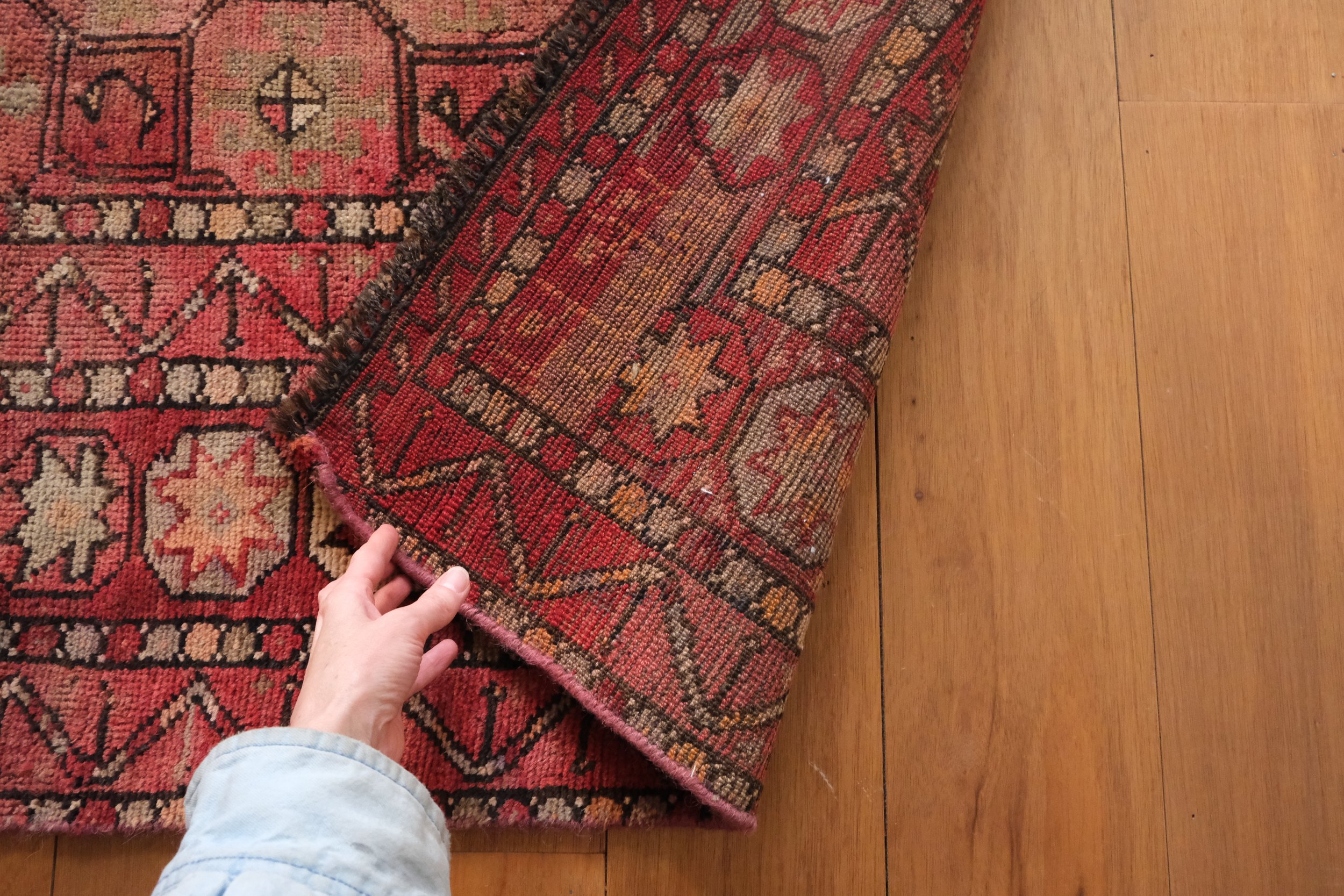 the backside corner of the rug and its hand knotted pattern