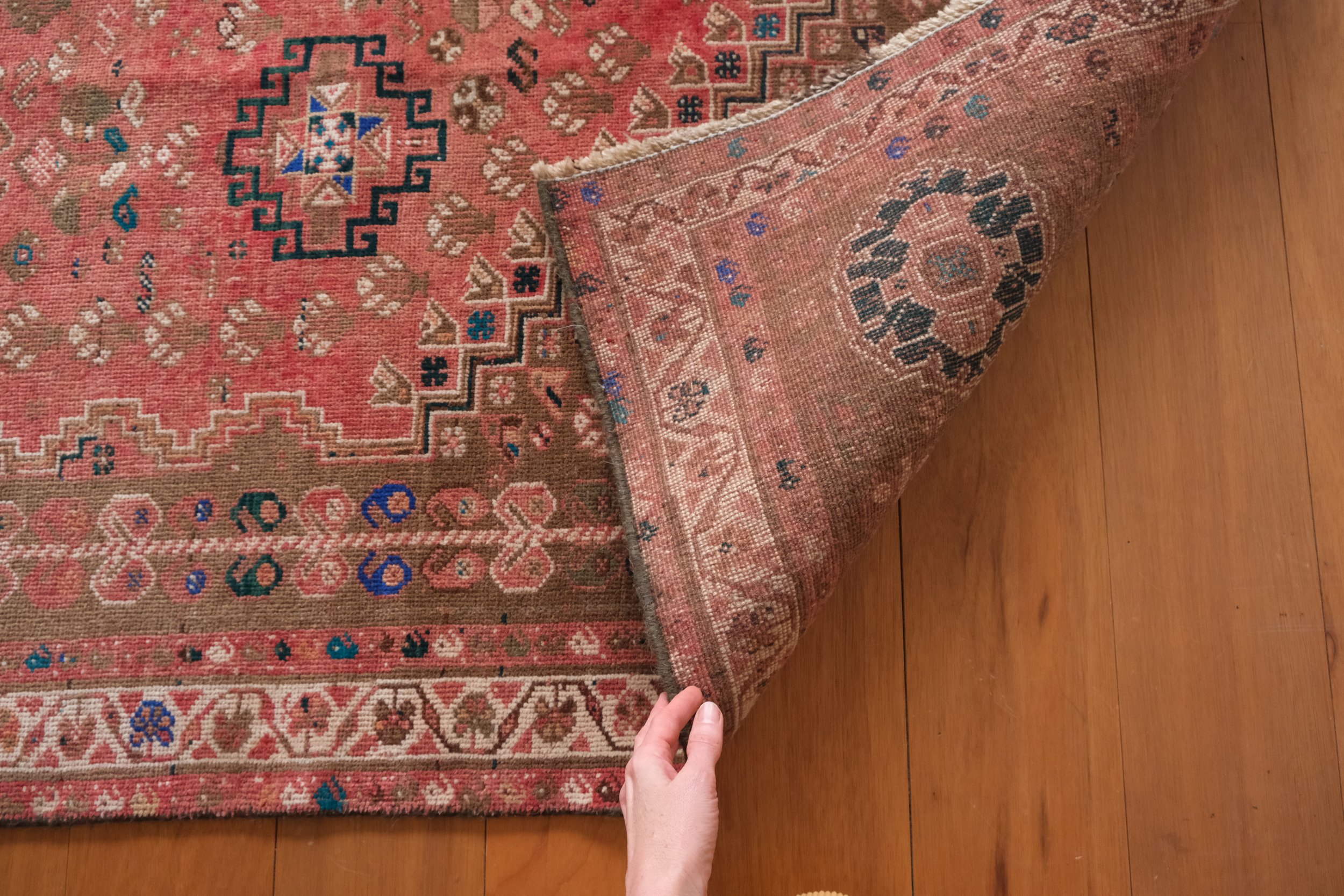 the backside of the rug shows its hand knotted qualities