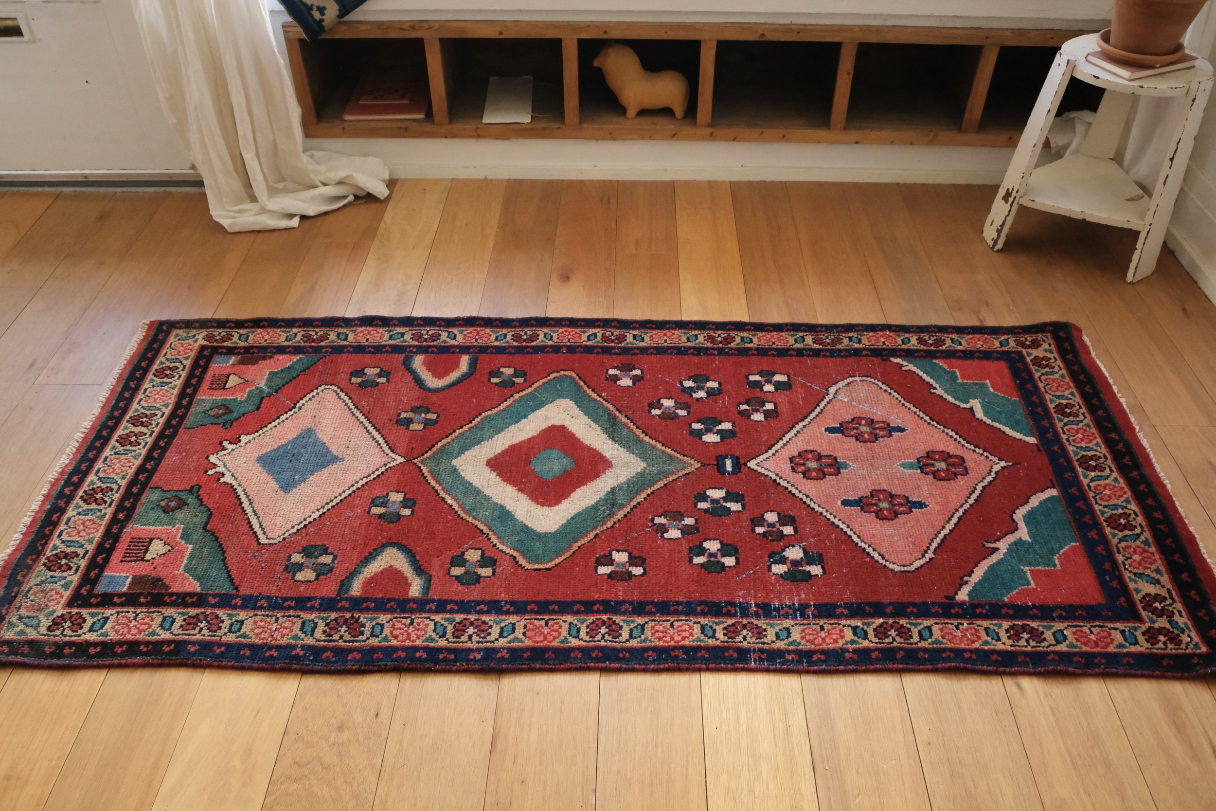 full view of vintage Gabbeh rug on wood floors